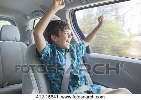 Enthusiastic boy cheering in back seat of car View Large Photo Image Stock Image - Enthusiastic boy cheering in back seat of car. Fotosearch