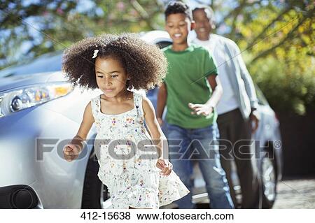 Family running outside car View Large Photo Image Stock Photo - Family running outside car. Fotosearch