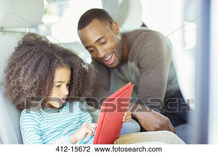 Father and daughter using digital tablet in back seat of car View Large Photo Image Stock Image - Father and daughter using digital tablet in back seat of car. Fotosearch