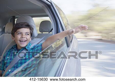 Happy boy sticking hand out window of car View Large Photo Image Stock Image - Happy boy sticking hand out window of car. Fotosearch