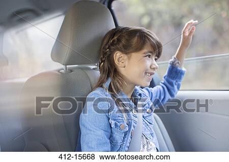 Happy girl sticking hand out car window View Large Photo Image Stock Photo - Happy girl sticking hand out car window. Fotosearch