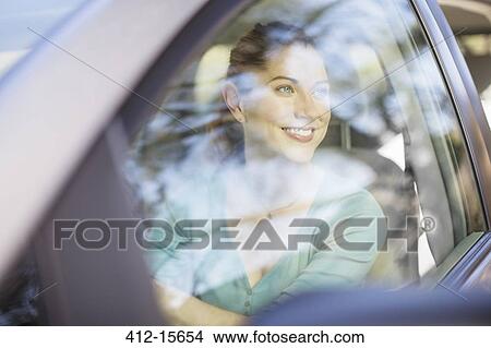 Picture - Happy woman driving car. Fotosearch