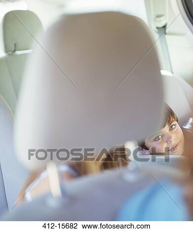 Mother turning to talk to children in back seat of car View Large Photo Image Stock Image - Mother turning to talk to children in back seat of car. Fotosearch