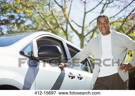 Portrait of confident senior man leaning against car View Large Photo Image Stock Photo - Portrait of confident senior man leaning against car. Fotosearch