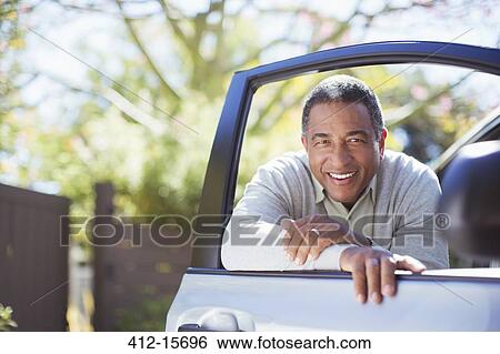 Portrait of confident senior man leaning against car door View Large Photo Image Stock Photograph - Portrait of confident senior man leaning against car door. Fotosearch