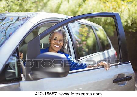 Portrait of confident senior woman getting out of car View Large Photo Image Stock Photo - Portrait of confident senior woman getting out of car. Fotosearch