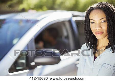 Portrait of confident woman outside of car View Large Photo Image Stock Image - Portrait of confident woman outside of car. Fotosearch
