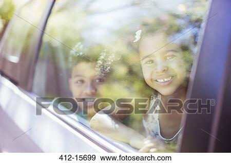 Portrait of happy brother and sister looking out car window View Large Photo Image Stock Photo - Portrait of happy brother and sister looking out car window. Fotosearch