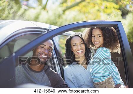 Portrait of happy family inside and outside of car View Large Photo Image Stock Image - Portrait of happy family inside and outside of car. Fotosearch
