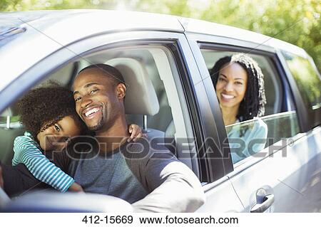 Stock Photo - Portrait of happy family inside car. Fotosearch