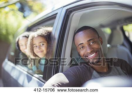 Stock Photograph - Portrait of happy family leaning out car windows. Fotosearch