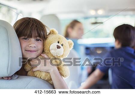 Portrait of happy girl with teddy bear in back seat of car View Large Photo Image Stock Image - Portrait of happy girl with teddy bear in back seat of car. Fotosearch