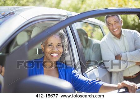Portrait of happy senior couple inside and outside of car View Large Photo Image Stock Photo - Portrait of happy senior couple inside and outside of car. Fotosearch