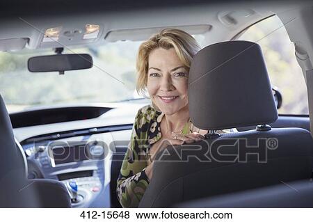 Stock Photo - Portrait of happy senior woman inside of car. Fotosearch
