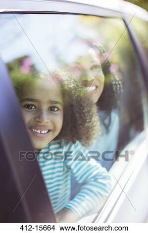 Picture - Portrait of smiling car looking out car window. Fotosearch
