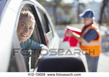 Stock Photo - Roadside mechanic filling gas tank for woman. Fotosearch