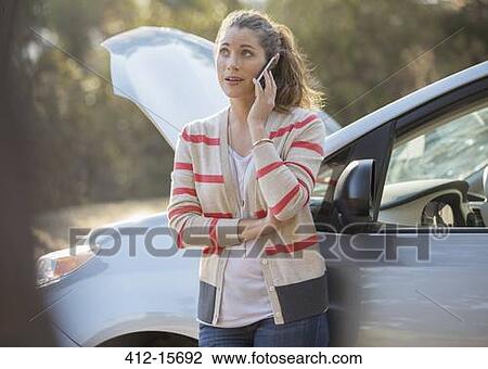 Woman talking on cell phone with automobile hood raised at roadside View Large Photo Image Stock Image - Woman talking on cell phone with automobile hood raised at roadside. Fotosearch