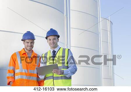 Portrait of businessman and worker with clipboard near silage storage towers View Large Photo Image Stock Image - Portrait of businessman and worker with clipboard near silage storage towers. Fotosearch