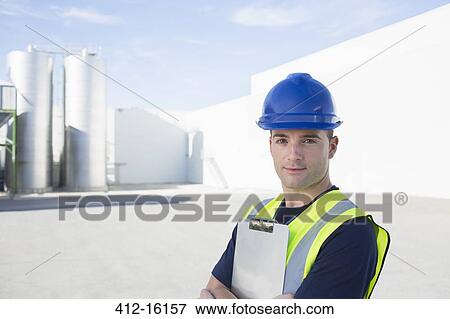 Stock Photo - Portrait of confident worker with clipboard at granary. Fotosearch