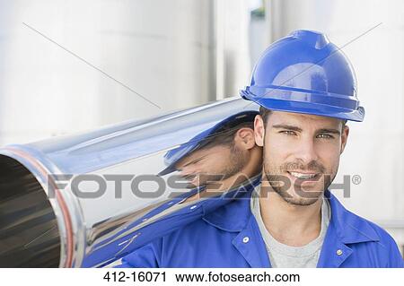 Portrait of smiling worker carrying stainless steel tube View Large Photo Image Stock Image - Portrait of smiling worker carrying stainless steel tube. Fotosearch