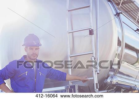 Picture - Portrait of worker at back of stainless steel milk tanker. Fotosearch