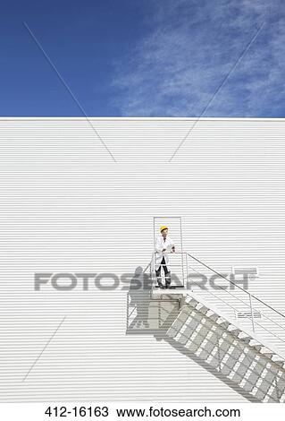 Scientist standing on platform against building View Large Photo Image Stock Image - Scientist standing on platform against building. Fotosearch