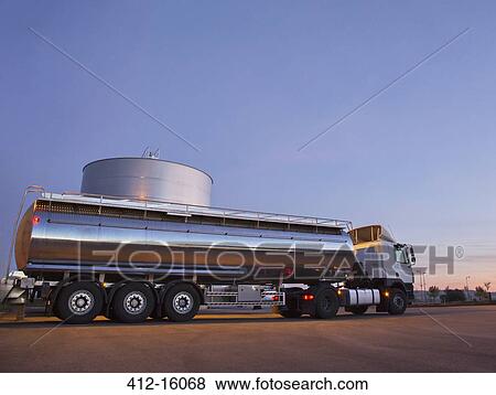 Stock Photo - Stainless steel milk tanker next to silage storage tower. Fotosearch
