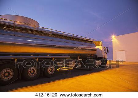 Stock Image - Stainless steel milk tanker parked at night. Fotosearch