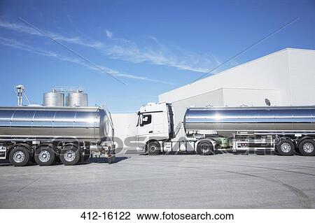 Stock Image - Stainless steel milk tankers parked. Fotosearch