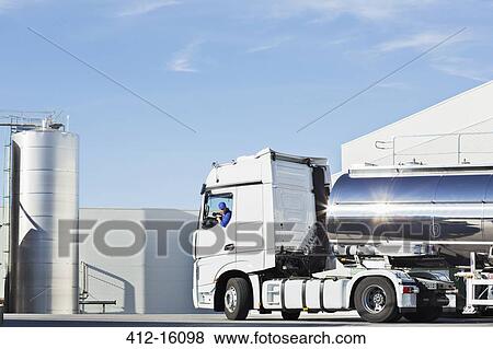 Truck driver parking stainless steel milk tanker outside silage storage tower View Large Photo Image Stock Photo - Truck driver parking stainless steel milk tanker outside silage storage tower. Fotosearch