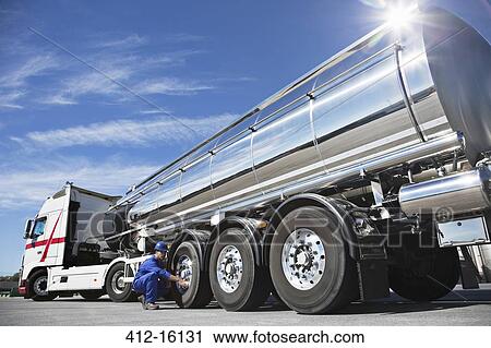 Worker checking tire on stainless steel milk tanker View Large Photo Image Stock Image - Worker checking tire on stainless steel milk tanker. Fotosearch