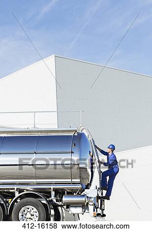 Worker climbing ladder at back of stainless steel milk tanker View Large Photo Image Stock Photo - Worker climbing ladder at back of stainless steel milk tanker. Fotosearch