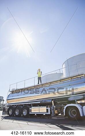 Worker standing on platform above stainless steel milk tanker View Large Photo Image Stock Image - Worker standing on platform above stainless steel milk tanker. Fotosearch