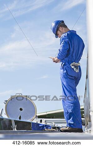 Worker using digital tablet on platform View Large Photo Image Stock Photography - Worker using digital tablet on platform. Fotosearch