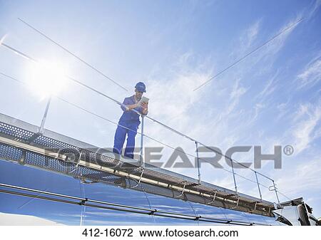 Worker with digital tablet standing on platform above stainless steel milk tanker View Large Photo Image Stock Image - Worker with digital tablet standing on platform above stainless steel milk tanker. Fotosearch