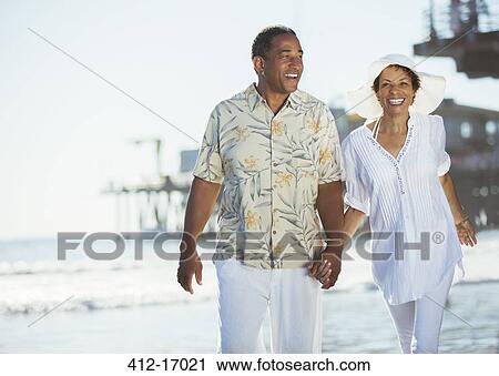 Couple holding hands and walking on beach View Large Photo Image Stock Image - Couple holding hands and walking on beach. Fotosearch