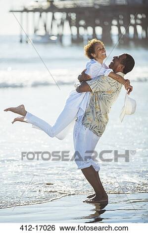 Couple hugging on beach View Large Photo Image Stock Photograph - Couple hugging on beach. Fotosearch