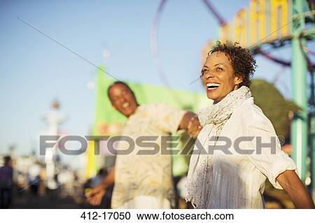 Enthusiastic couple at amusement park View Large Photo Image Stock Image - Enthusiastic couple at amusement park. Fotosearch