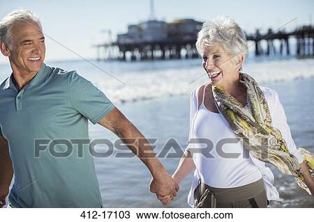 Enthusiastic senior couple running on beach View Large Photo Image Stock Image - Enthusiastic senior couple running on beach. Fotosearch