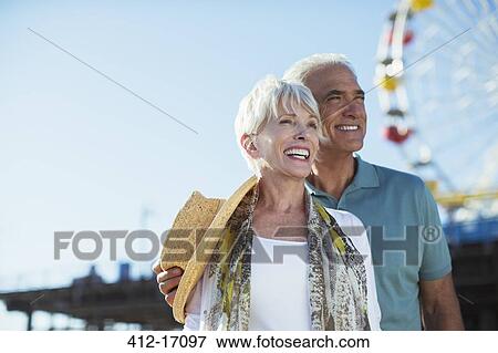 Stock Photo - Happy senior couple at amusement park. Fotosearch