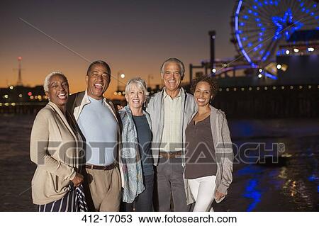 Stock Image - Portrait of senior friends on beach at night. Fotosearch
