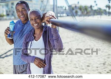 Portrait of smiling senior couple on beach playground View Large Photo Image Stock Photo - Portrait of smiling senior couple on beach playground. Fotosearch