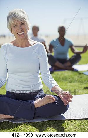 Portrait of smiling senior woman practicing yoga in park View Large Photo Image Stock Image - Portrait of smiling senior woman practicing yoga in park. Fotosearch