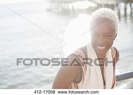 Portrait of smiling woman at oceanfront View Large Photo Image Stock Photo - Portrait of smiling woman at oceanfront. Fotosearch