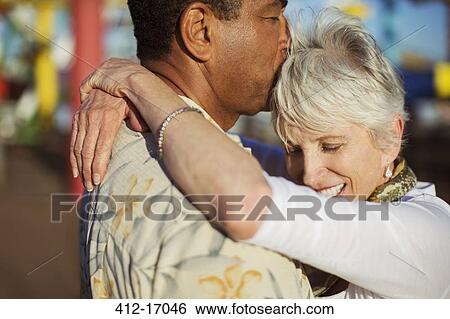 Stock Photograph - Senior couple kissing outdoors. Fotosearch