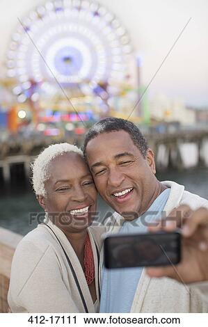 Senior couple taking selfie at amusement park View Large Photo Image Stock Image - Senior couple taking selfie at amusement park. Fotosearch