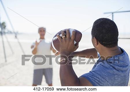 Senior men playing football on beach View Large Photo Image Stock Photo - Senior men playing football on beach. Fotosearch