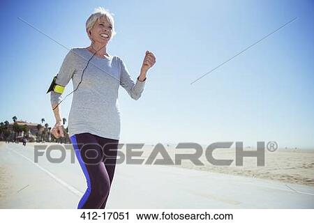 Senior woman jogging on beach boardwalk View Large Photo Image Stock Image - Senior woman jogging on beach boardwalk. Fotosearch