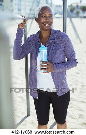 Woman in sportswear leaning on bar at beach playground View Large Photo Image Stock Photo - Woman in sportswear leaning on bar at beach playground. Fotosearch