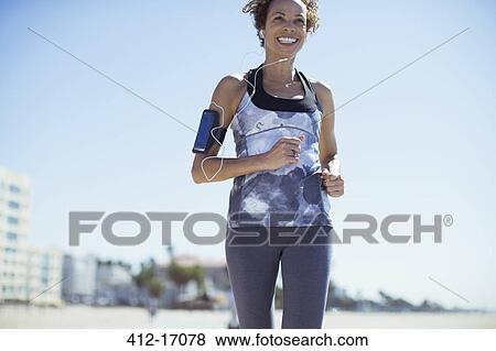 Woman jogging on beach View Large Photo Image Stock Photo - Woman jogging on beach. Fotosearch